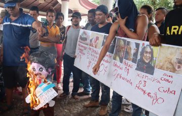 En protesta por cumbre migrantes queman piñatas de presidentes